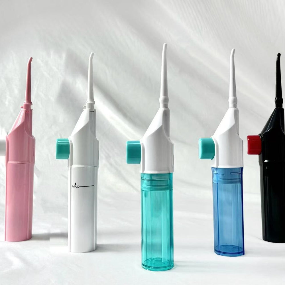 Five Diaflow water flossers in pink, white, teal, blue and black standing upright in a row on a white background