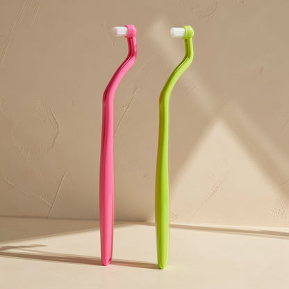 Adult manual toothbrush with a small head and tapered single-tuft bristles