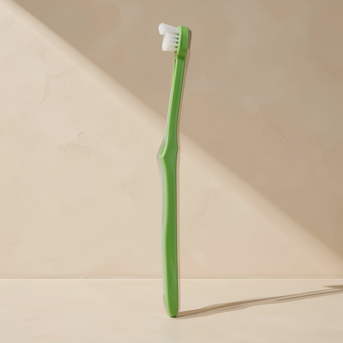 Manual toothbrush with a small head, soft bristles, and a single-tuft design - view 2
