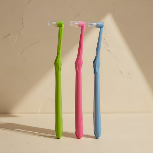 Manual toothbrush with a small tapered single-tuft head and soft bristles