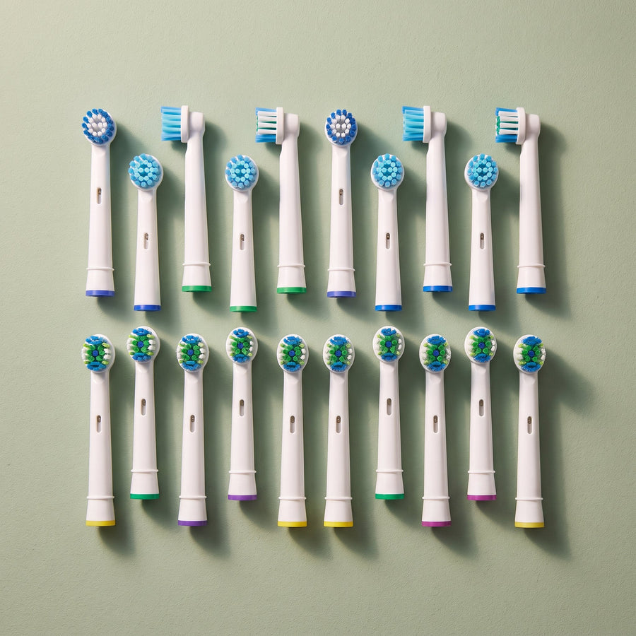 OralCove replacement toothbrush heads grouped neatly on a pale sage surface.